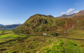 Вид на покрытую зеленью гору под голубым небом
