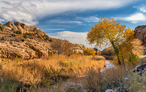 Вид на каменные горы под небом с белыми облаками осенью