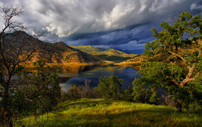 Черные грозовые облака над озером в горах 