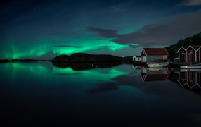 Дома на берегу озера на фоне полярного сияния 
