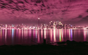 Ночной город под голубым небом отражается в воде 