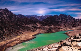 Река между высоких гор под голубым небом 