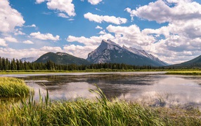 Красивое горное озеро под голубым небом с белыми облаками
