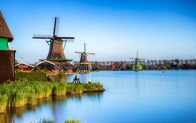 Мельницы  на берегу озера под голубым небом 