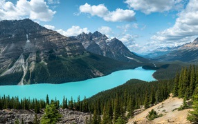 Тень от белых облаков на горном массиве у голубого озера