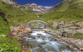 Маленький каменный мост через горную реку 