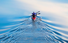 Два спортсмена на лодке плывут по реке 