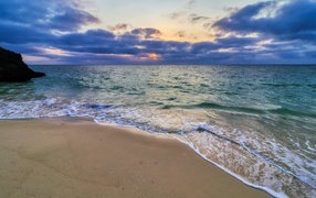 Голубая морская вода на песке на закате солнца