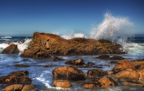 Stormy sea waves beat against stones