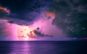 Stormy sky with black clouds with lightning over the sea