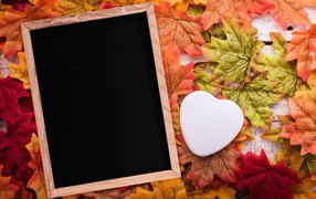 Рамка для фото на опавших листьях с белым сердцем