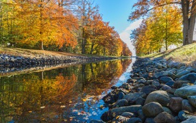 Камни на берегу маленькой реки в осеннем парке