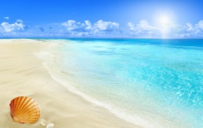 Clear blue ocean water on a white sand beach in summer