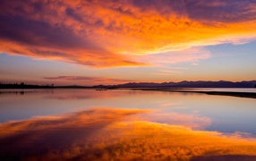 Красивое небо на закате отражается в спокойной воде озера