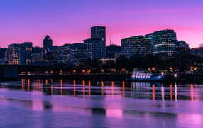 Сиреневый закат над ночным городом у реки