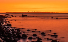 Камни на берегу моря на закате в сумерках 
