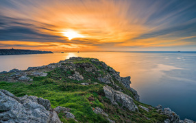 View from the cliff at a beautiful sunset in the sky over a calm sea