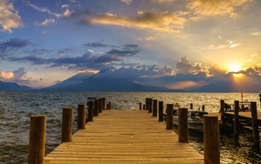 Wooden bridge to the sea at sunset