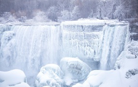 A frozen waterfall flows down the rocks in winter