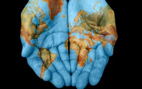 Руки с картой мира на черном фоне 