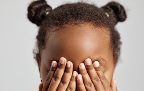 Темнокожая девочка закрыла глаза 