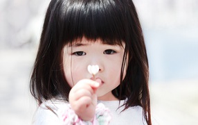 Маленькая девочка азиатка с цветком