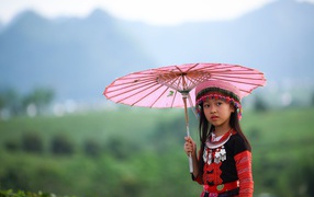 Маленькая девочка азиатка с розовым зонтом