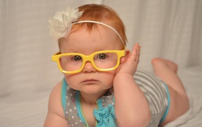 Маленькая красивая девочка в очках с обручем на голове