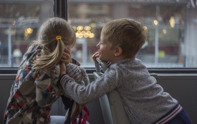 Маленькие девочка и мальчик сидят в автобусе 