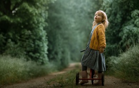 Маленькая девочка на трехколесном велосипеде 