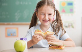 Улыбающаяся девушка школьница в столовой 