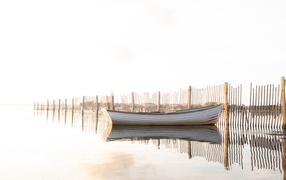 Лодка в воде у ограждения 