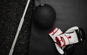 Gloves and a golf ball lie in the gym