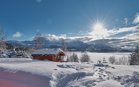 Яркое зимнее солнце у заснеженных гор, Норвегия