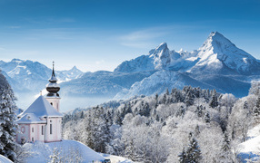 Храм у леса на фоне заснеженных гор 