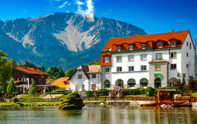 Большой красивый белый дом у подножия горы, Австрия 