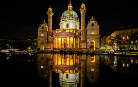 Старая церковь Карлскирхе ночью отражается в воде, Вена. Австрия