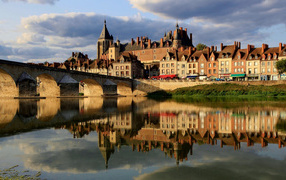 Large house is reflected in the river near the bridge, France