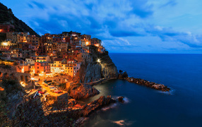 The beautiful night city of Manarola on the edge of a cliff, Italy