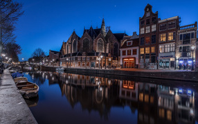 Houses reflected in canal water at night, Netherlands