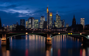 Небоскребы отражаются в воде ночью 