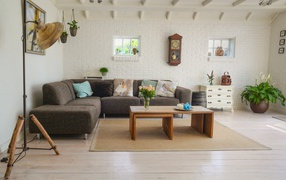A large sofa stands in a spacious bright living room