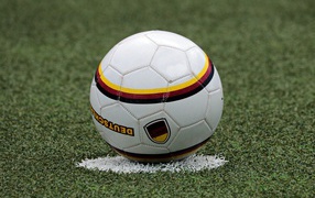 A soccer ball lies on a label on the field