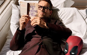 Актер Райан Рейнольдс лежит с книгой на кровати