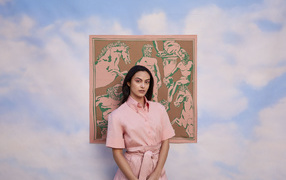 Актриса Камила Мендес в розовом платье на фоне картины 