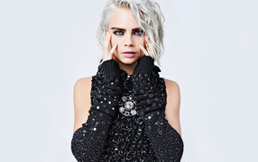 Актриса Кара Делевинь в черном наряде на сером фоне