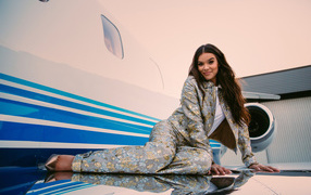 Актриса Хейли Стейнфилд в костюме лежит на крыле самолета