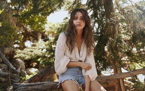 Актриса Джессика Альба сидит на сухом дереве 