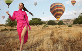 Актриса Виктория Джастис в красном платье на поле с воздушными шарами 