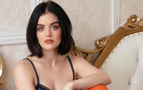 Красивая девушка, актриса Люси Хейл сидит на диване